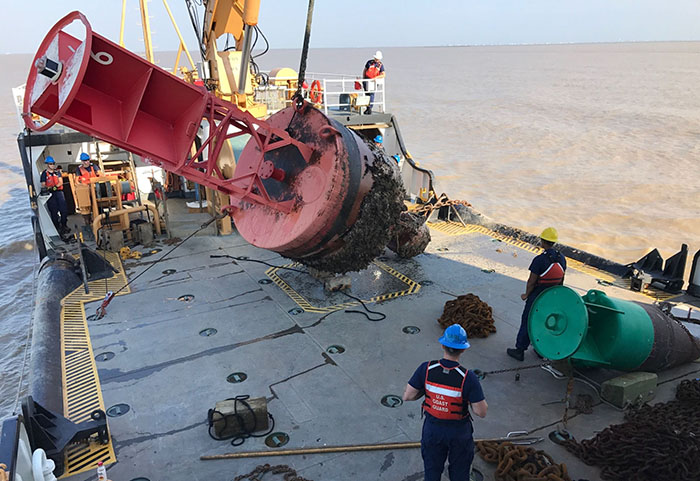 Members of the US Coast Guard examine and repair navigational aids in the waters around Houston.